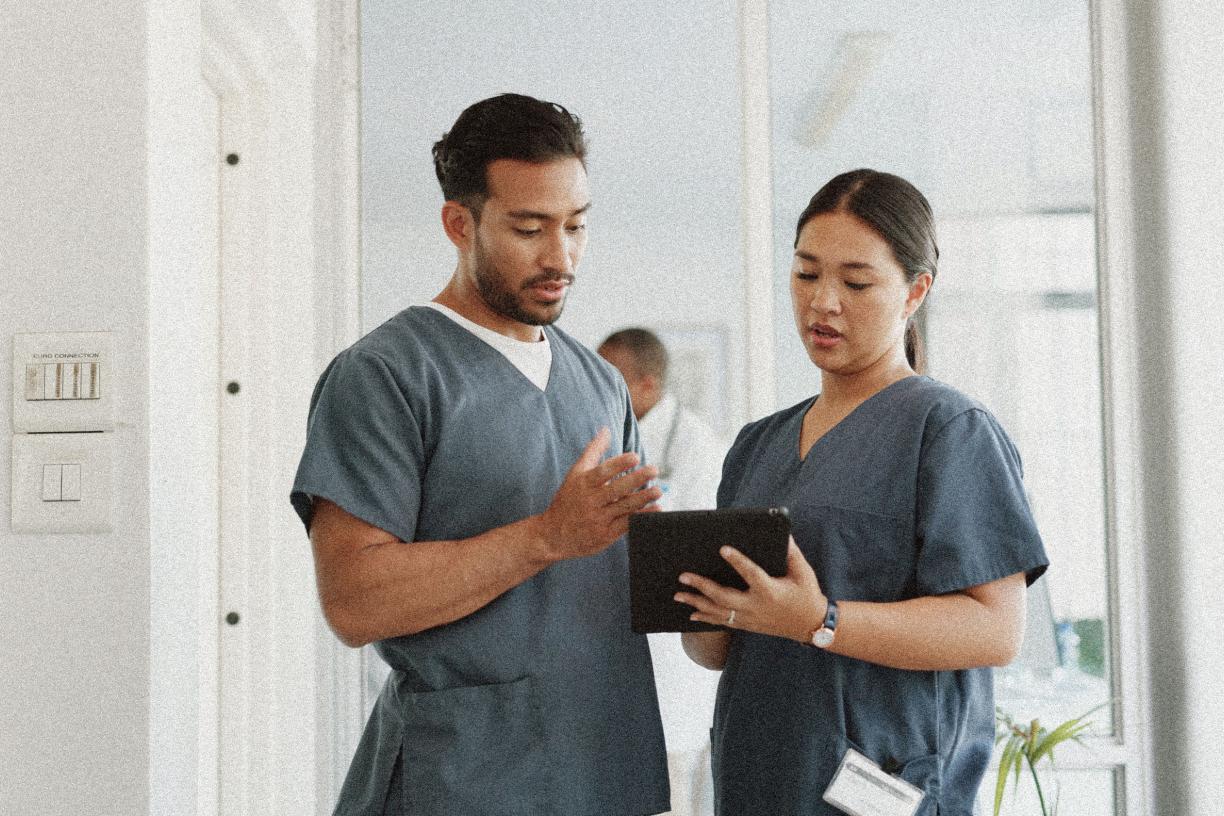 Two nurses looking at an ipad in a clinic. 
