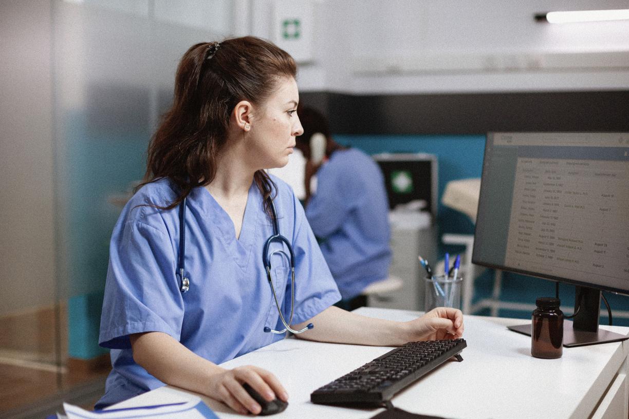 A doctor looking at an MRI on a screen in a clinic. 