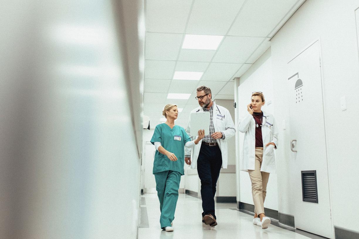 A group of doctors walking down a hospital hallway.