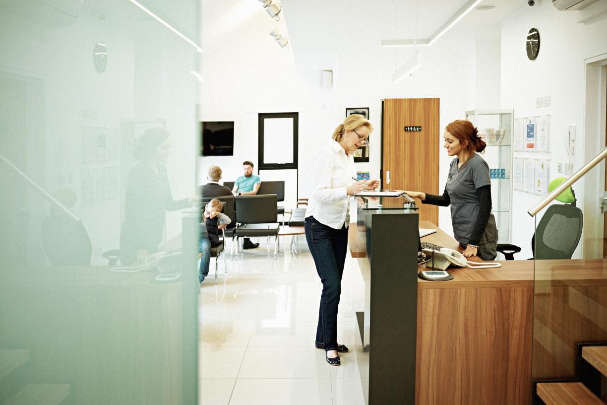person at reception desk in doctors office