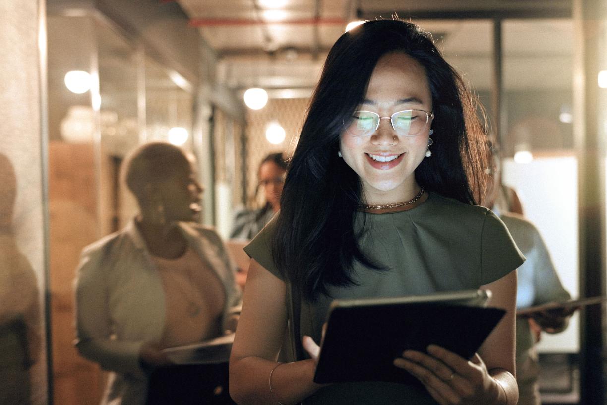 a health care worker looking at an iPad in an office