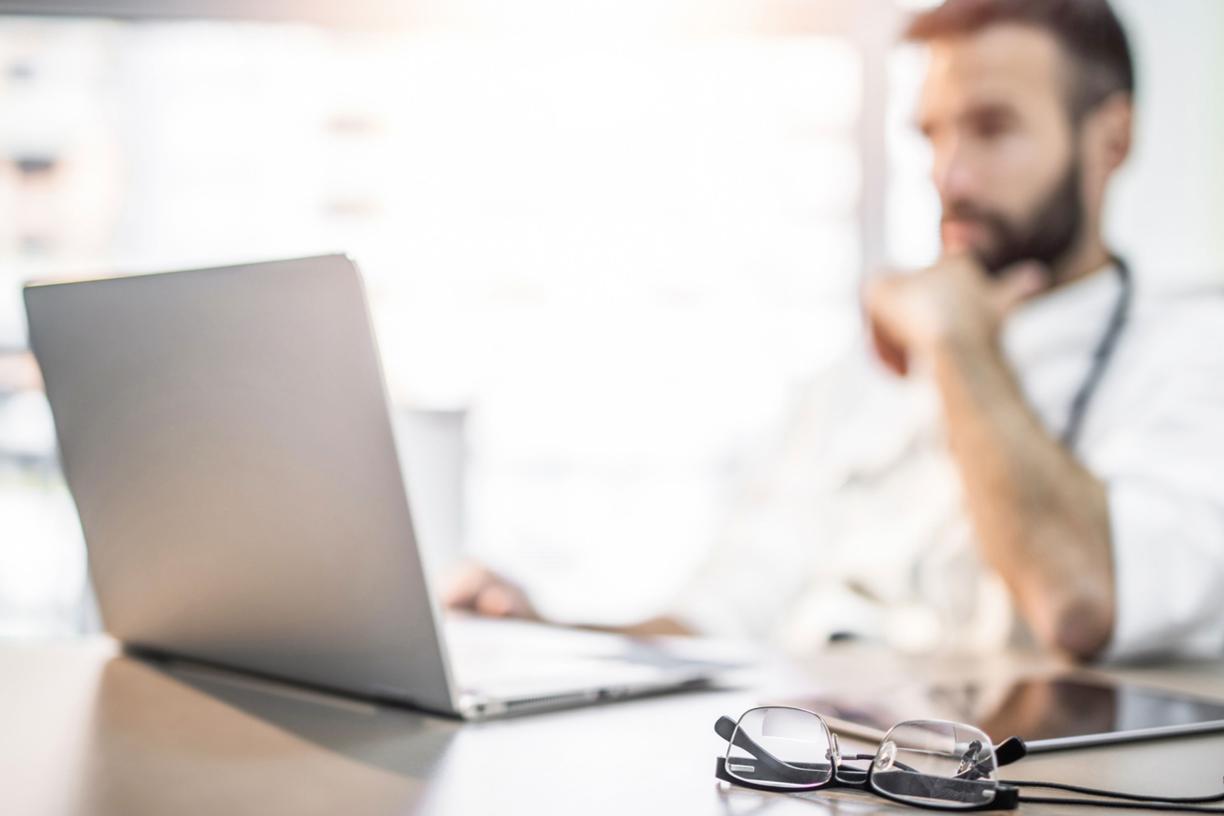physician looking at a lap top