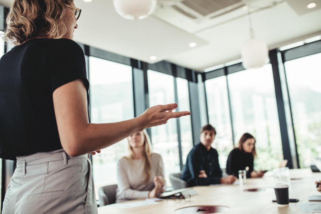 Business woman presenting to colleagues in board room.