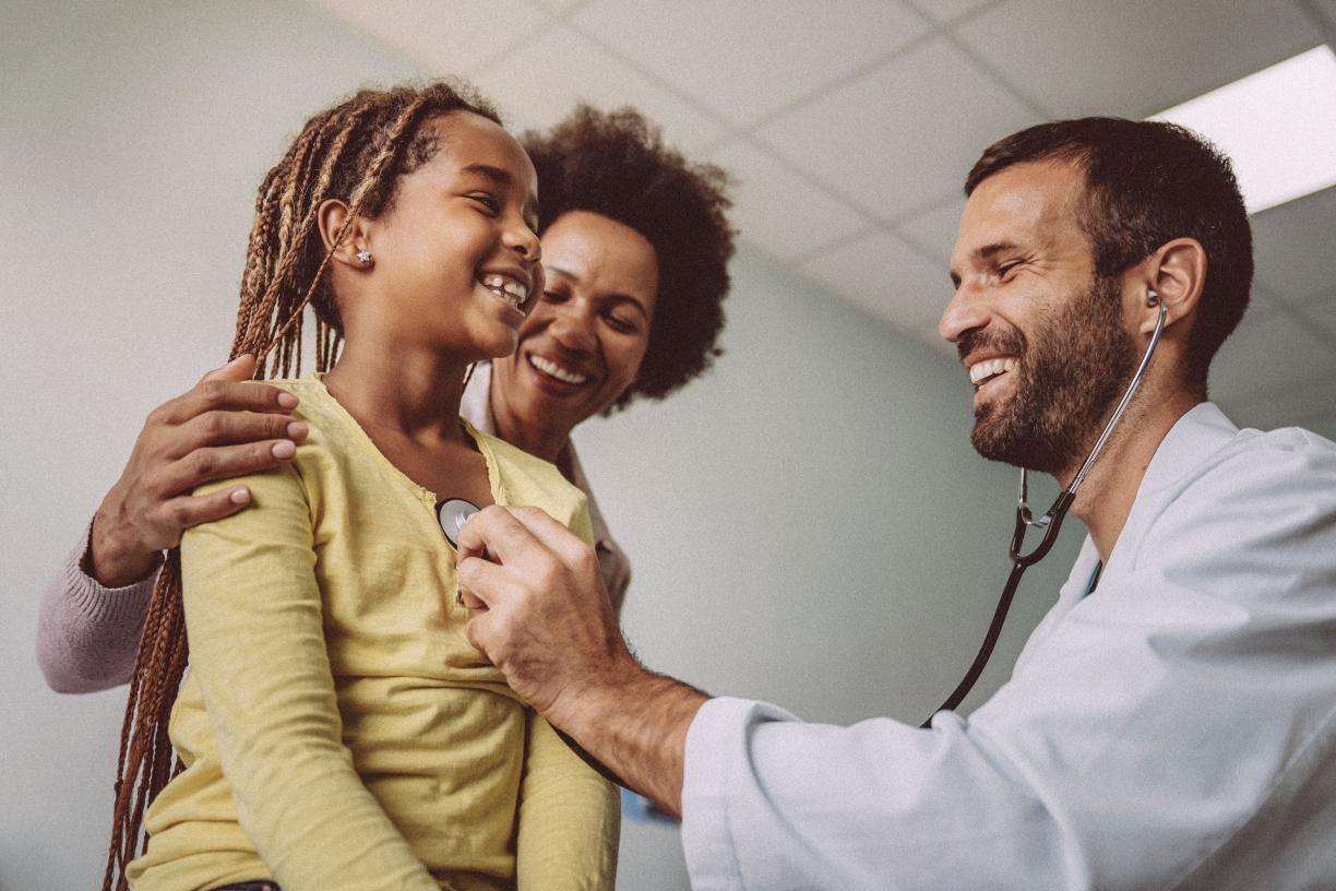 A doctors examines a young patient's heart