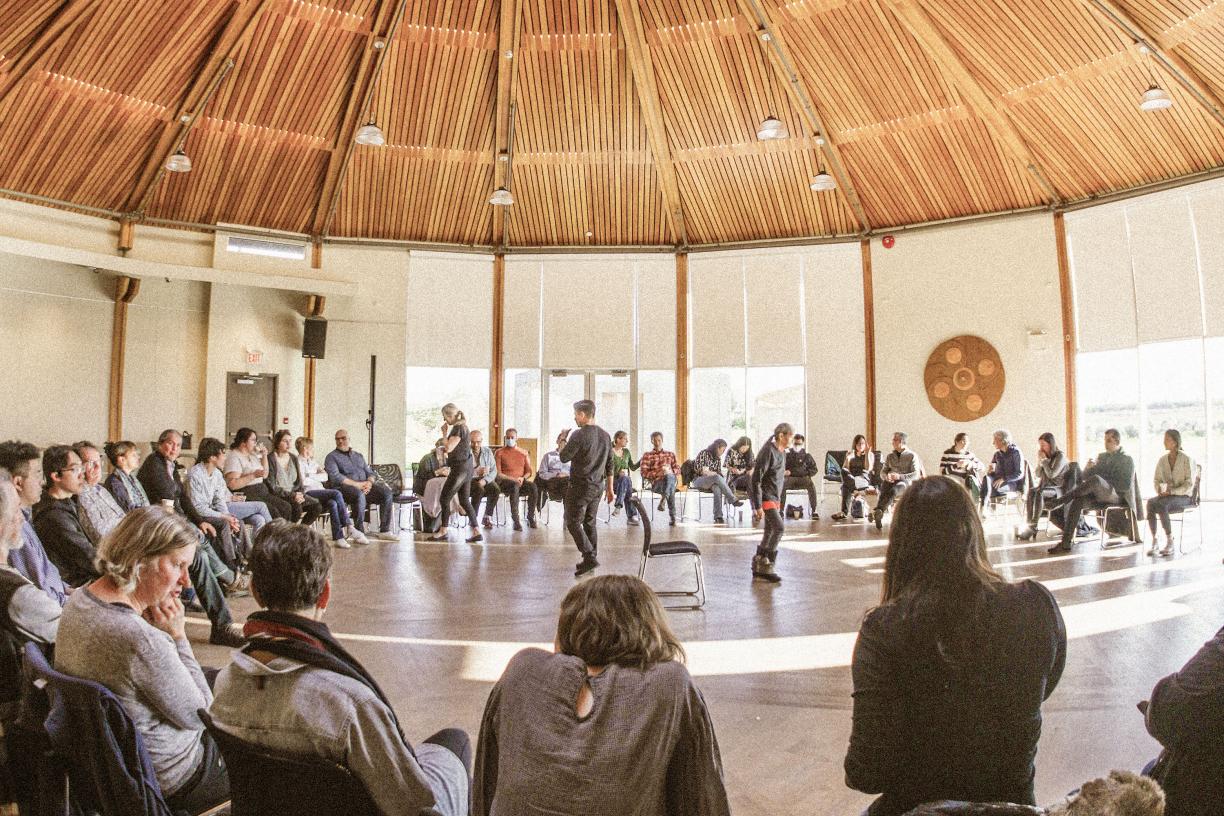 A circle of people participating in a Musqueam First Nations community-based learning session