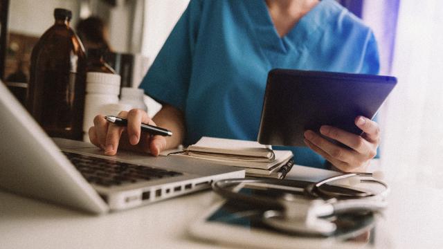 close up doctor working on laptop with iPad