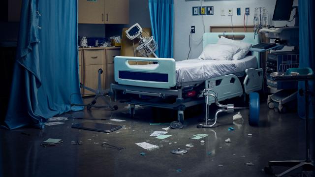 Hospital room in disarray, with medical equipment knocked over and papers and debris scattered across the floor after a violent incident.